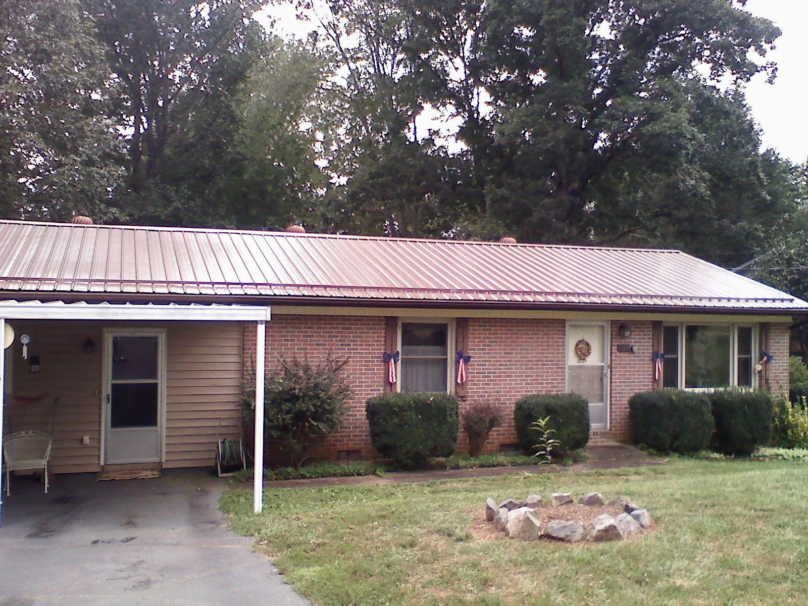 Bronze metal roof and carport on a brick ranch home — Roof Repair work by our crew in Kirkwood