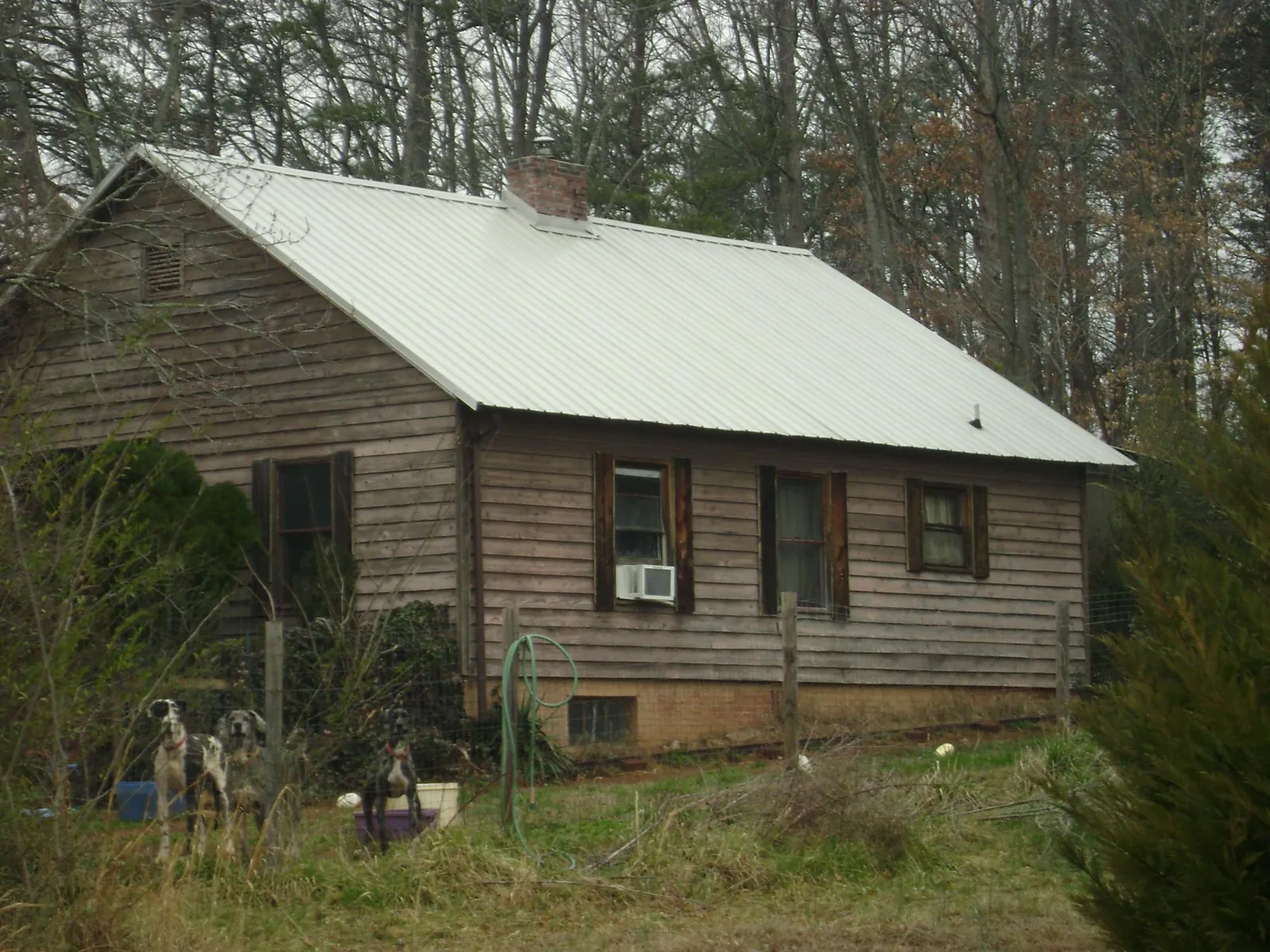 White metal roof on an old wood sided farmhouse, from a Metal Roof Installation job in Kirkwood